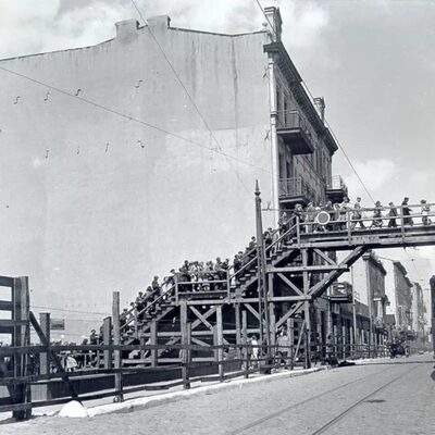 Eine alte Aufnahme. Zu sehen ist eine Holzbrücke in Lodz. Sie verbindet zwei Teile des Ghettos Litzmannstadt miteinander. Viele Leute sind auf der Brücke.