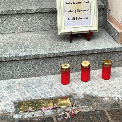 Zu sehen sind 3 Stolpersteine mit Friedhofskerzen in der Stendaler Innenstadt.
