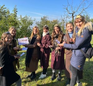 Die Weinköniginnen stehen im Halbkreis und präsentieren die Flyer mit Bildungsurlauben