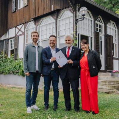 Vor der Villa übergibt Armin Willingmann, Minister für Wissenschaft, Energie, Klimaschutz und Umwelt und erster Stellvertreter des Ministerpräsidenten des Landes Sachsen-Anhalt die Förderurkunde an Geschäftsführer Maximilian Schmidt, stellv. Geschäftsführer Benjamin Gehne und Akademieleiterin Claudia Berge.
