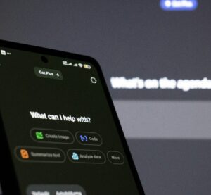 Es ist ein Handy zu sehen auf dem eine KI geöffnet ist und gerade fragt wie sie helfen kann.