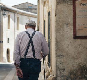ein Rentner geht eine Straße entlang