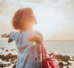 eine Person steht in der Sonne am Strand