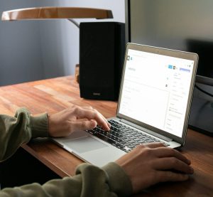 eine Person sitzt am Laptop und tippt in einem Websitebuilder