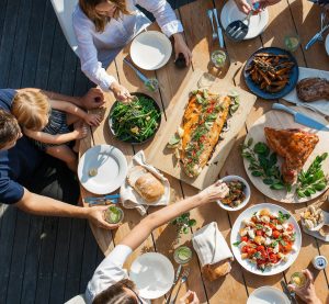 ein Tisch mit Essen und mehreren Pesonen