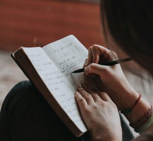 eine Person, die in ein Notizbuch schreibt