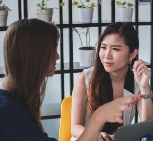 zwei redende Frauen, wobei eine von beiden ernst bis wütend schaut