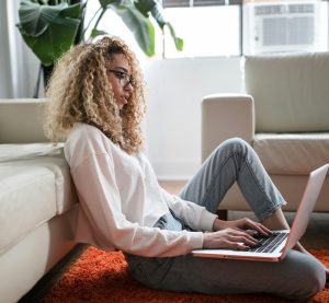 eine Frau, die an ihrem Laptop sitzt und tippt