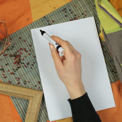 eine schreibende Hand über einmal weißen Blatt Papier