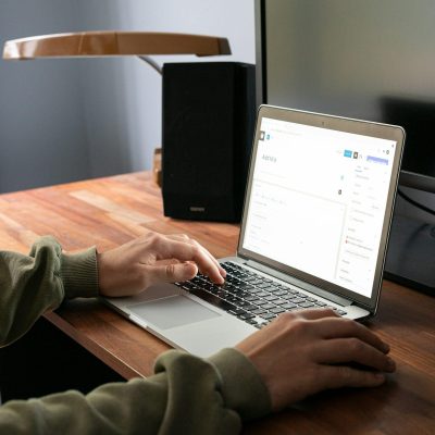 eine Person sitzt am Laptop und tippt in einem Websitebuilder