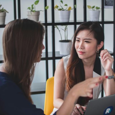 zwei redende Frauen, wobei eine von beiden ernst bis wütend schaut