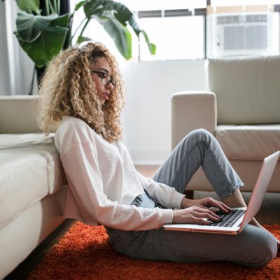 eine Frau, die an ihrem Laptop sitzt und tippt
