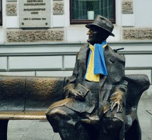 Bronzeskulptur eines Mannes mit Hund sitzend auf einer Bank
