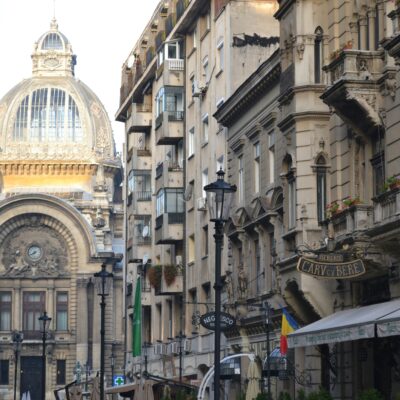 Das Bild zeigt die Altstadt von Bukarest. Im Hintergrund ist das markante Gebäude der CEC-Palast (Palatul CEC), eines der bekanntesten historischen Bauwerke der rumänischen Hauptstadt.