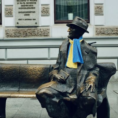 Bronzeskulptur eines Mannes mit Hund sitzend auf einer Bank