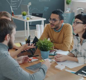 Vier Personen sitzen an einem Tisch und diskutieren.