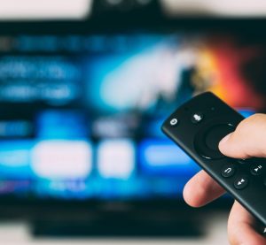 eine Fernbedienung wird in Richtung des Fernsehers gehalten