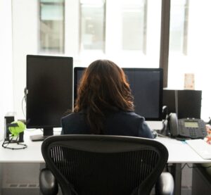 A person at a desk photographed from behind