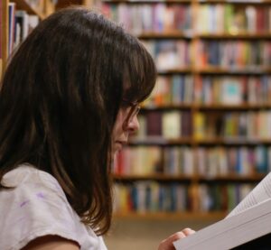 ein lesende Person in einer Bibliothek