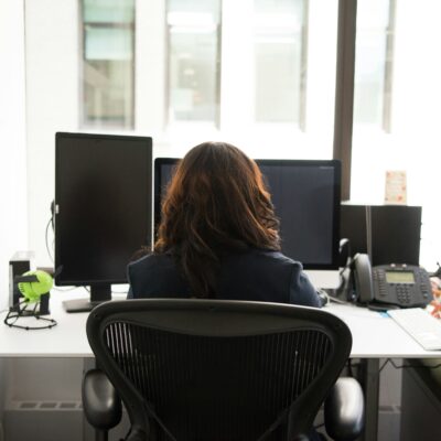 A person at a desk photographed from behind