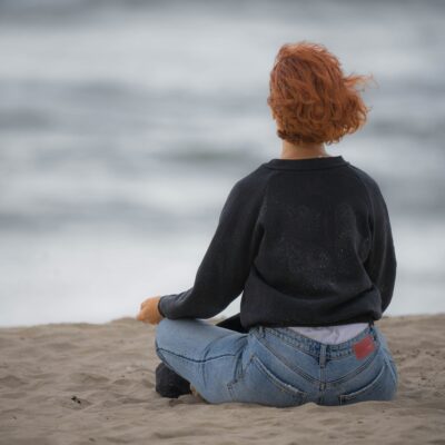 Mindful person sits on the beach.