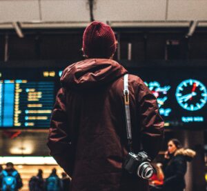 Eine Person steht vor dem Fluganzeiger am Flughafen
