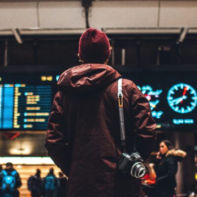 Eine Person steht vor dem Fluganzeiger am Flughafen