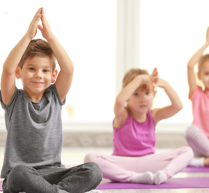 Drei kleine Kinder beim Yoga.