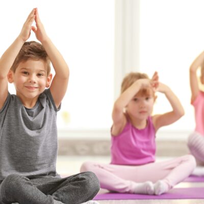 Drei kleine Kinder beim Yoga.