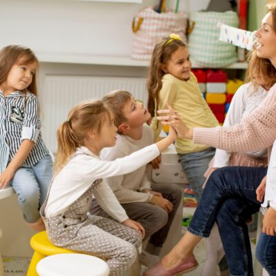 Eine Frau wird von sechs Kindern in Beschlag genommen.