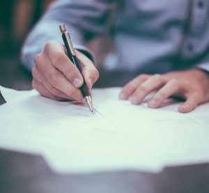 schreibende Person mit Papier