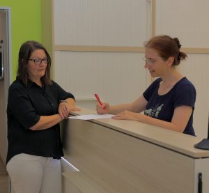 Eine Frau berät eine Person zu den Angeboten von Arbeit Und Leben Niedersachsen im Eingangsbereich der Geschäftsstelle Braunschweig.