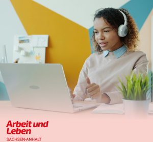 Eine Junge Frau sitzt mit Kopfhörern vor ihrem Laptop.