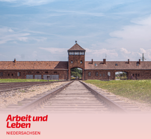 Blick auf das Vernichtungslager Ausschwitz mit dem markanten Eingangstor und den Gleisen