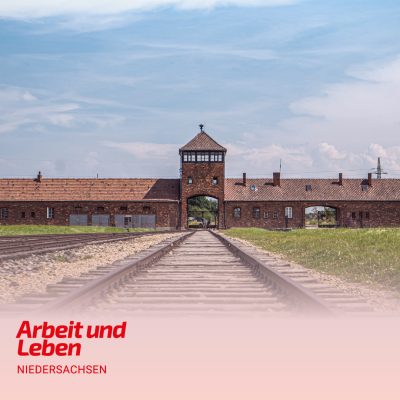 Blick auf das Vernichtungslager Ausschwitz mit dem markanten Eingangstor und den Gleisen